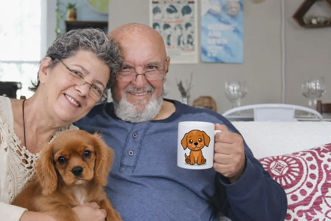 Un couple de grands-parents, le chiot sur les genoux, le mug à la main