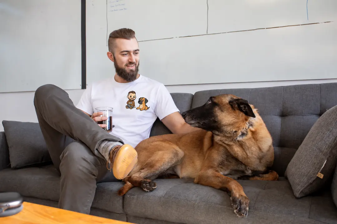 Un homme et son malinois sur le canapé, tous les deux dessinés sur son t-shirt